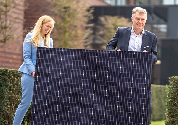 V.l.n.r.: Nachhaltigkeitsmanagerin Esther Höggemann und Vorstandsmitglied Jürgen Feistmann tragen ein Photovoltaikpaneel