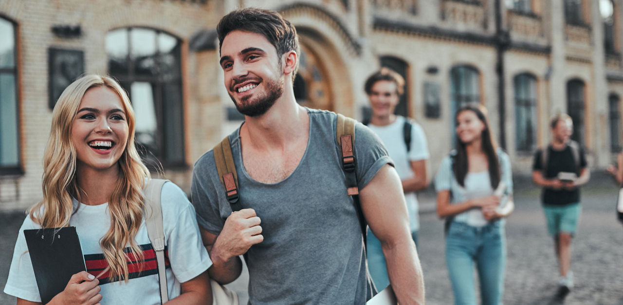 Zwei junge Personen laufen nebeneinander und lachen
