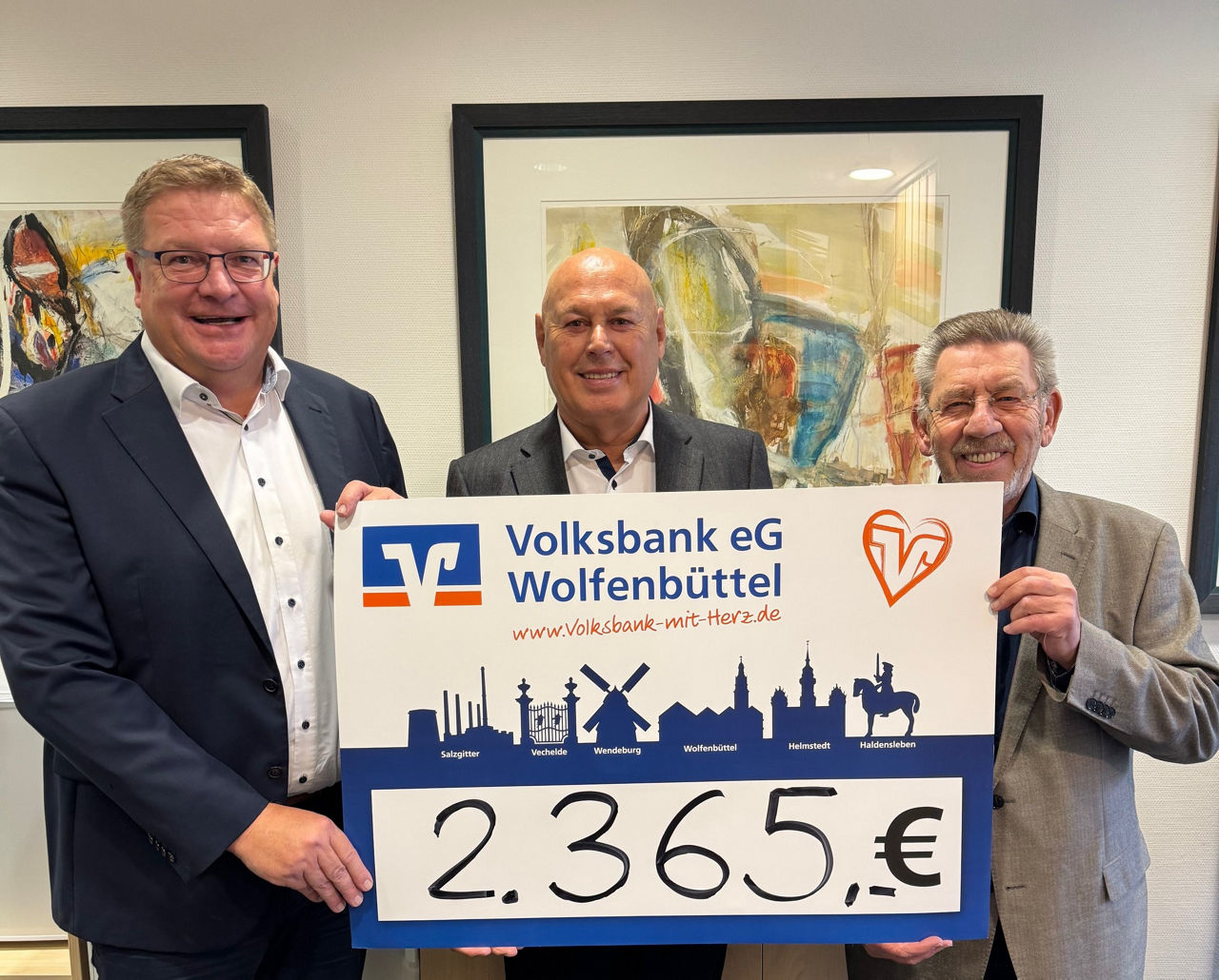Drei Männer halten ein großes Schild