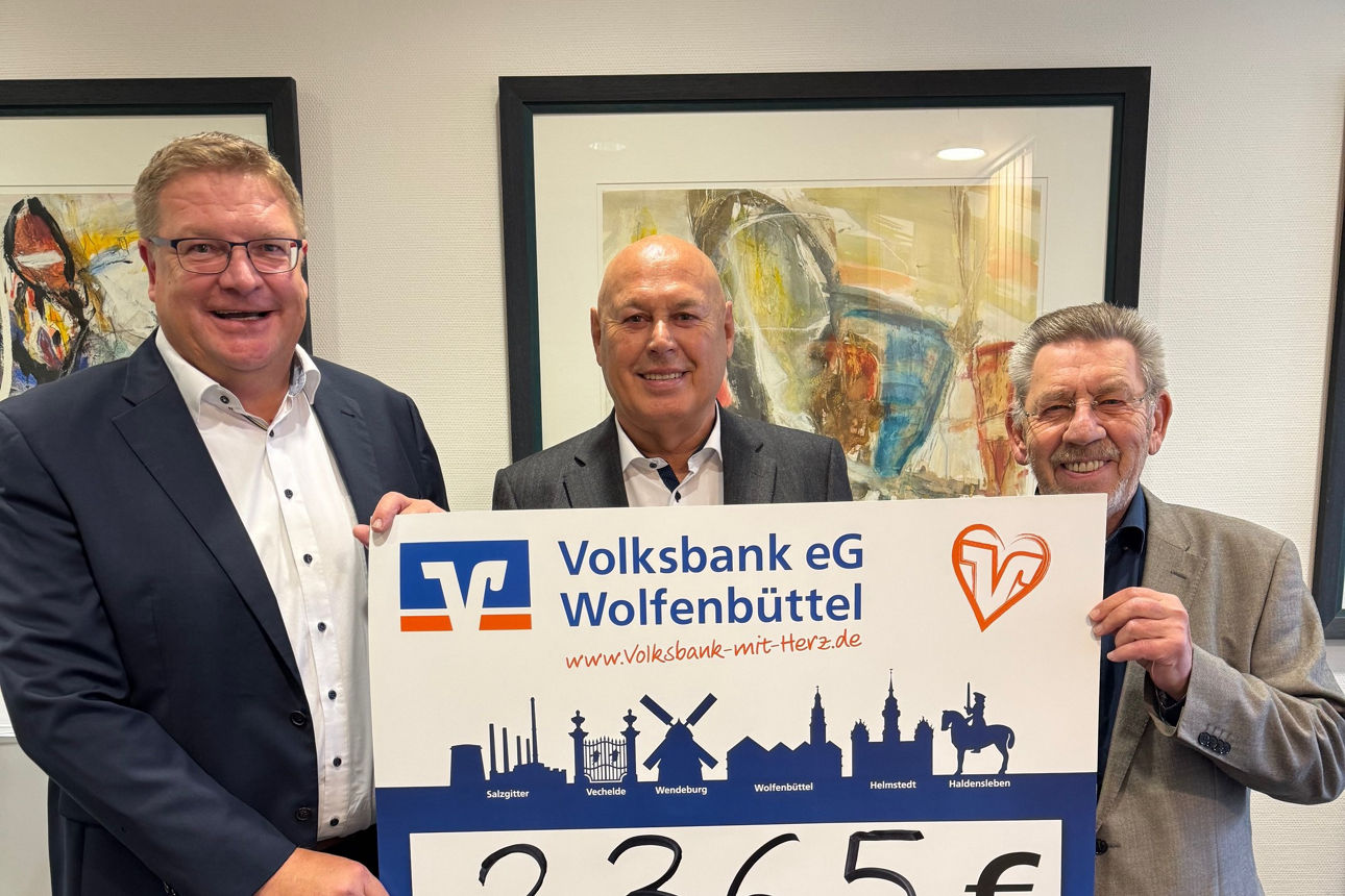 Drei Männer halten ein großes Schild