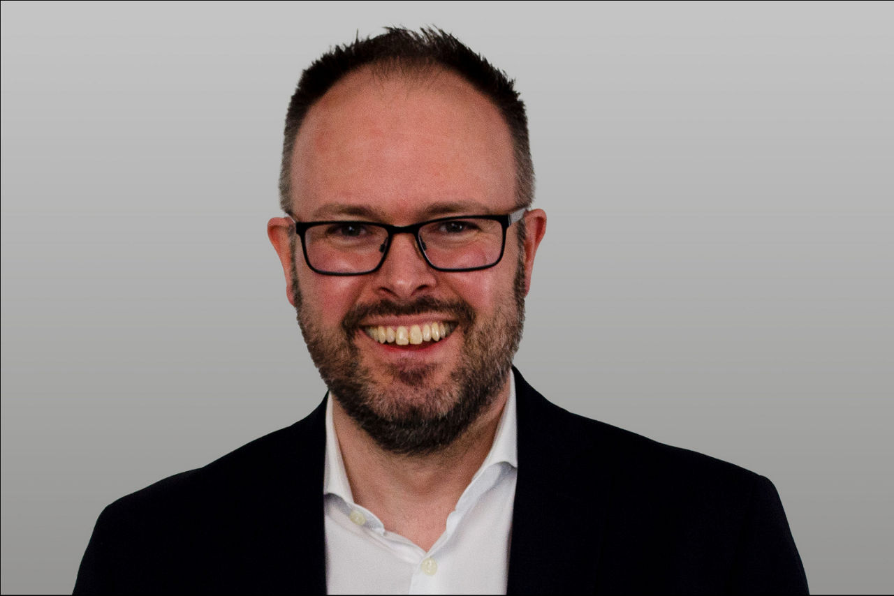 Bereichsleiter Baufinanzierung Andre Stepahn vor grauen Hintergrund