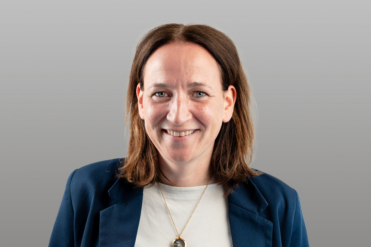 Baufinanzierungsspezialist Annika Hollmann-vom Bey vor grauen Hintergrund