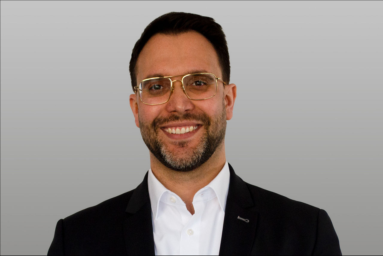Regionalleiter Baufinanzierung Daniele Venditti  vor grauen Hintergrund