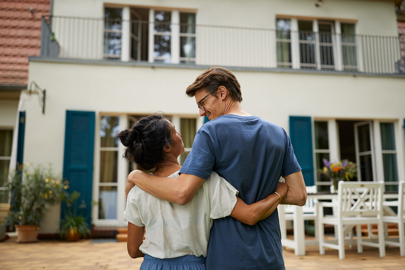 Junges Paar steht vor Haus