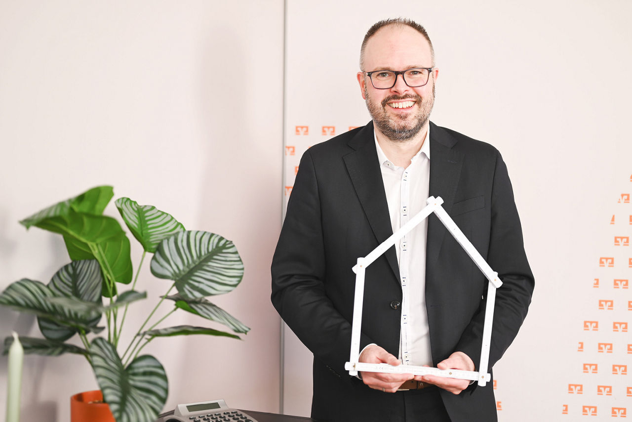 Kollegin sitzt mit Baufihaus und Taschenrechner im Büro
