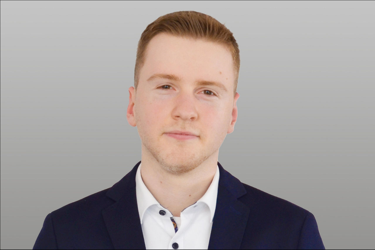 Baufinanzierungsspezialist Jan Schmalenbach vor grauen Hintergrund