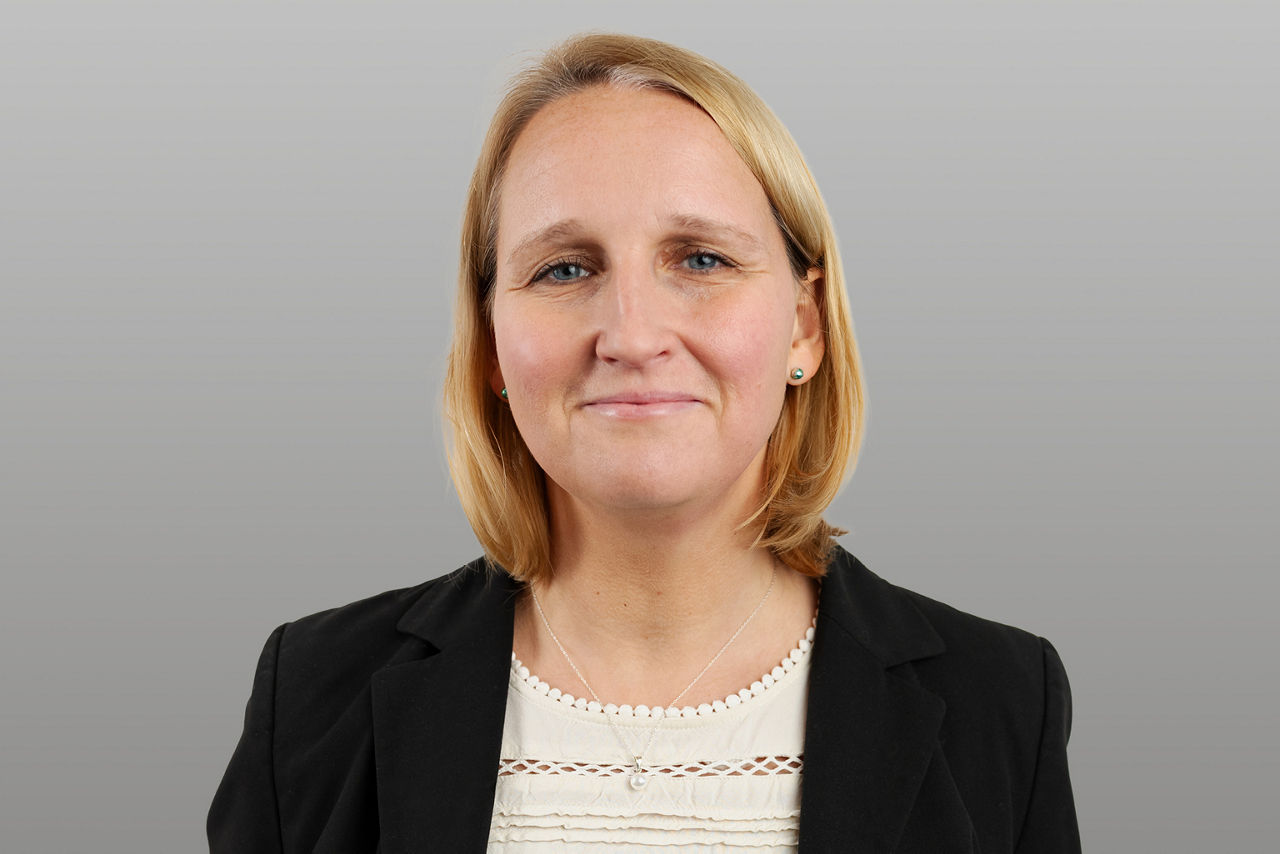 Baufinanzierungsspezialistin Vanessa Arntzen vor grauen Hintergrund