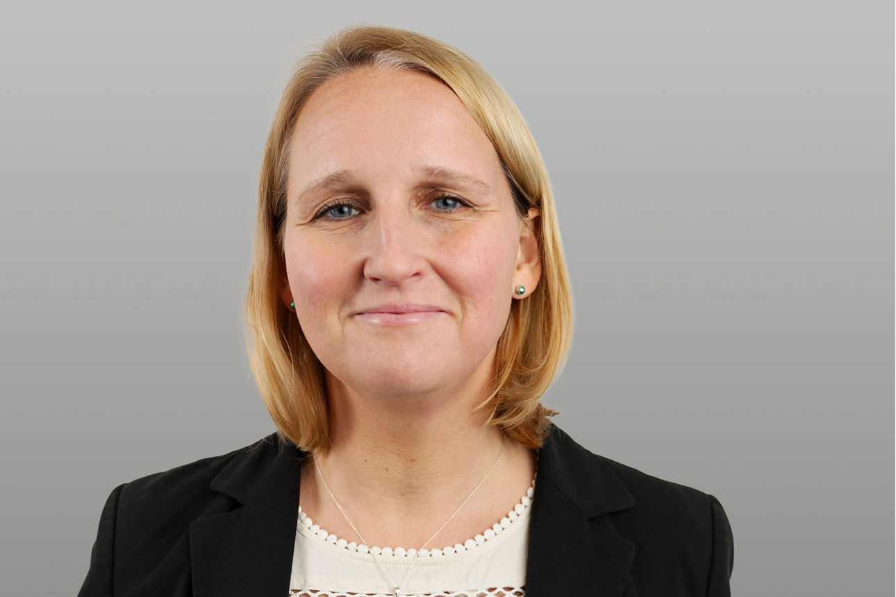 Baufinanzierungsspezialistin Vanessa Arntzen vor grauen Hintergrund