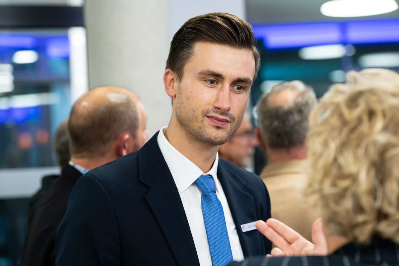 Zwei Männer und zwei Frauen stehen lächelnd nebeneinander