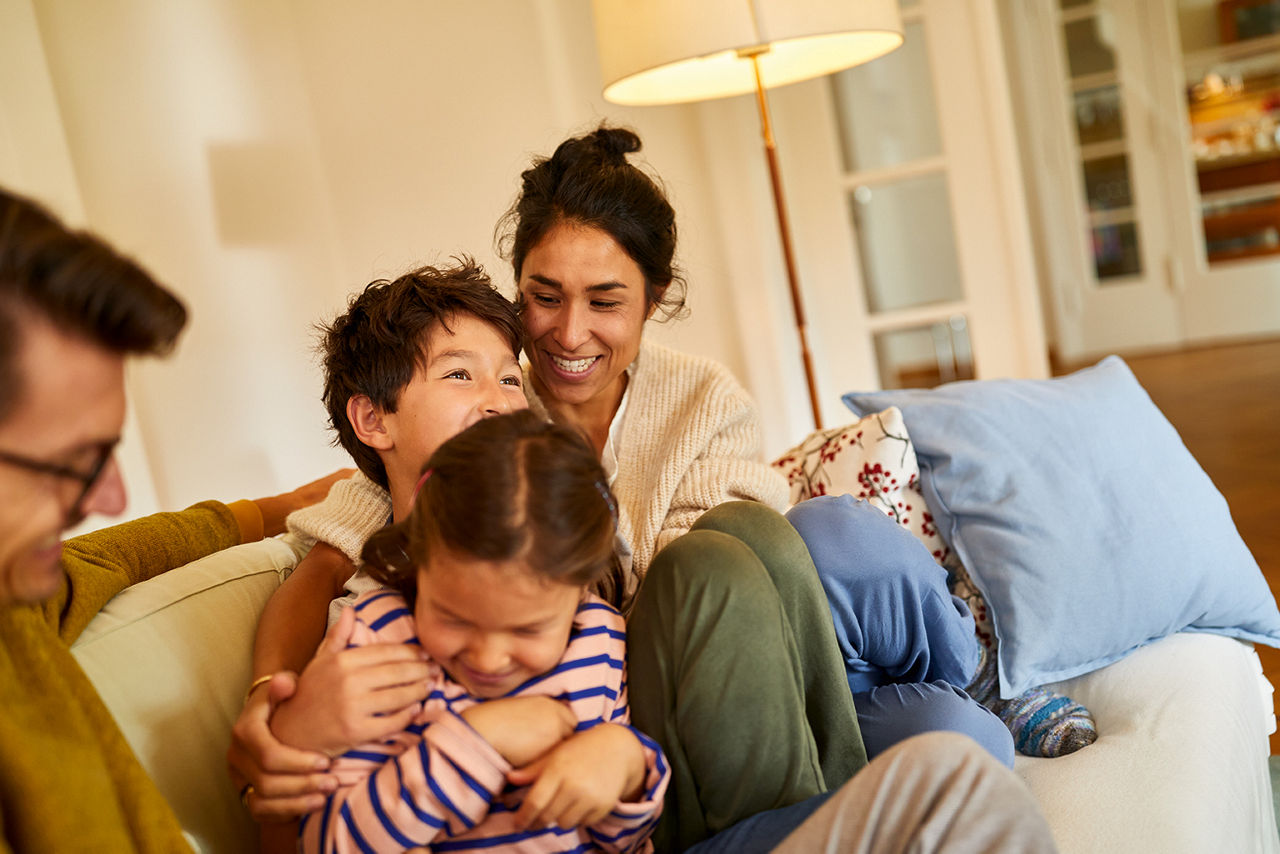 Familie sitzt glücklich auf der Couch