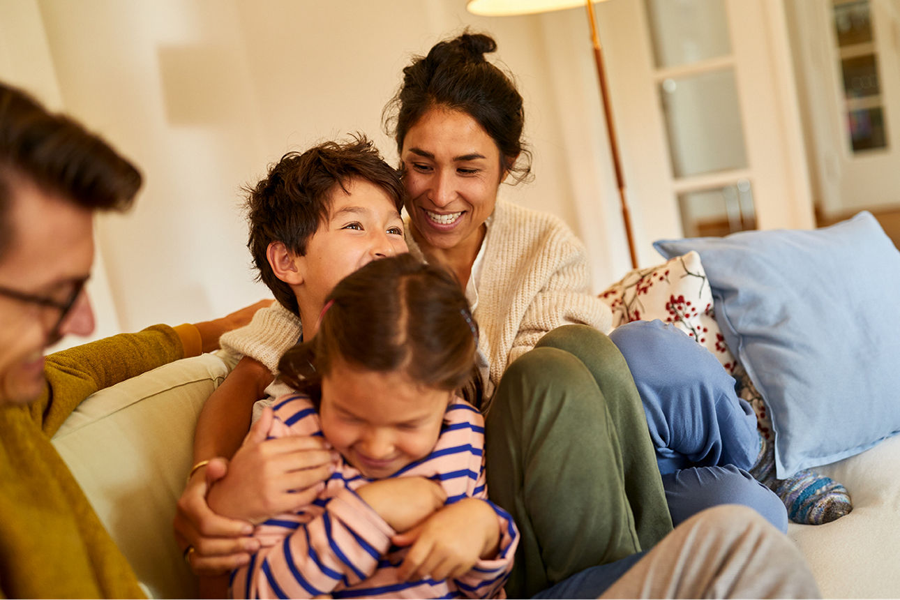 Familie sitzt glücklich auf der Couch