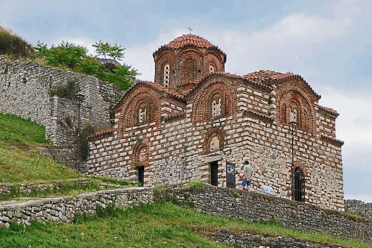 Die Burganlage von Berat liegt auf einem grünen Abhang.