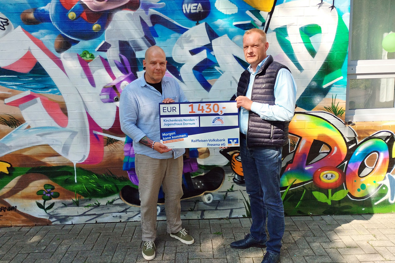 Jan-Wilko Noosten übergibt den symbolischen Scheck an Sven Jordan