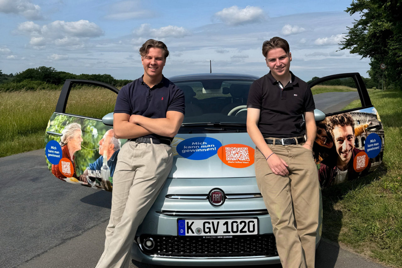 Unsere zwei Azubis stehen vor dem Gewinnspar-Auto