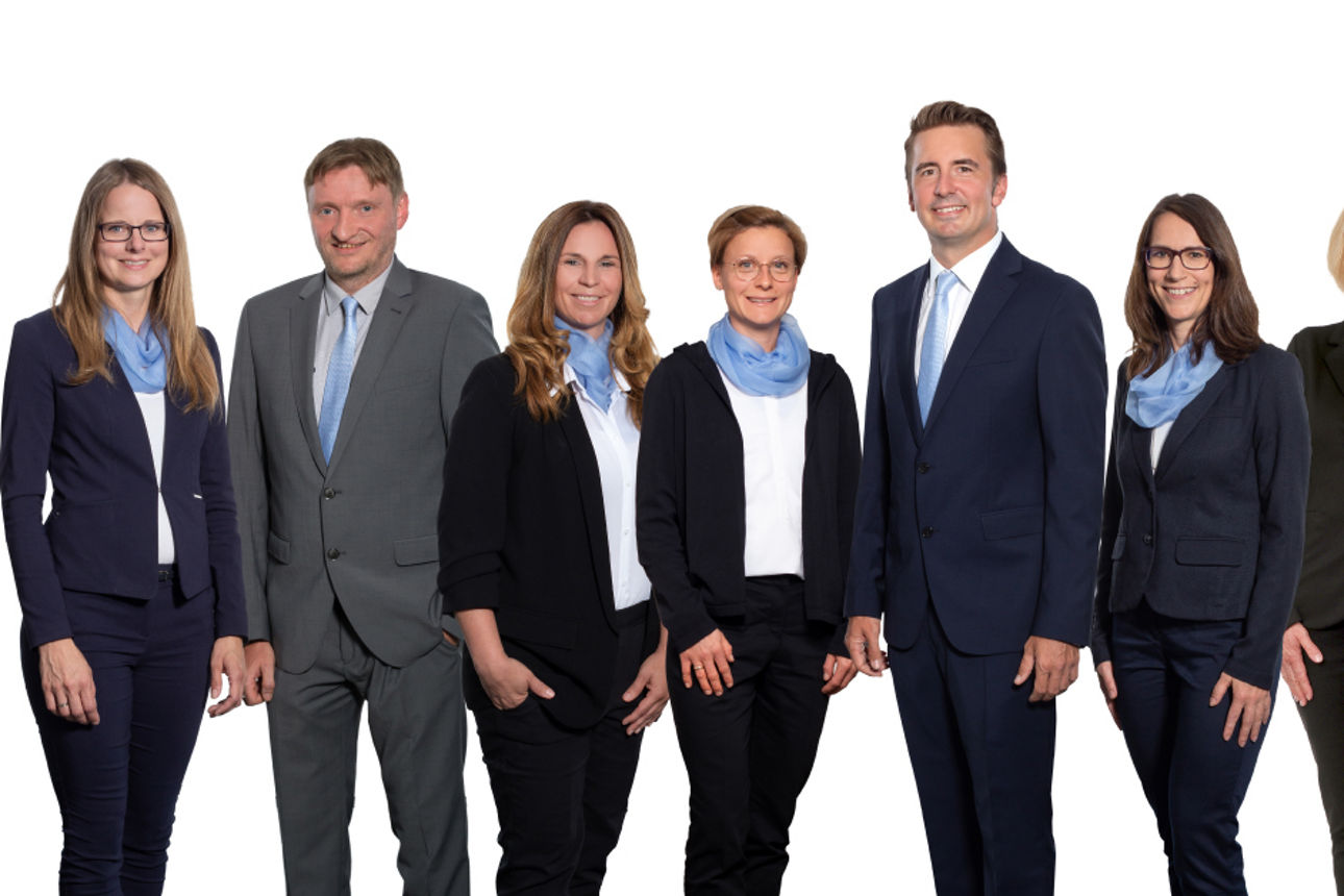 Fünf Frauen und drei Männer nebeneinander aufgestellt. Alle lächeln freundlich.