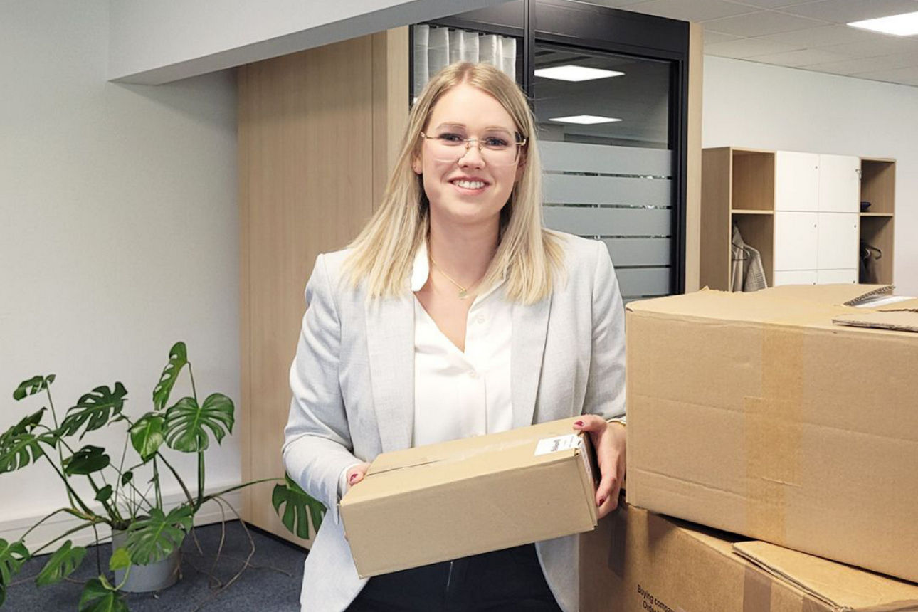 Janina Maitworm steht mit Umzugskartons im Büro