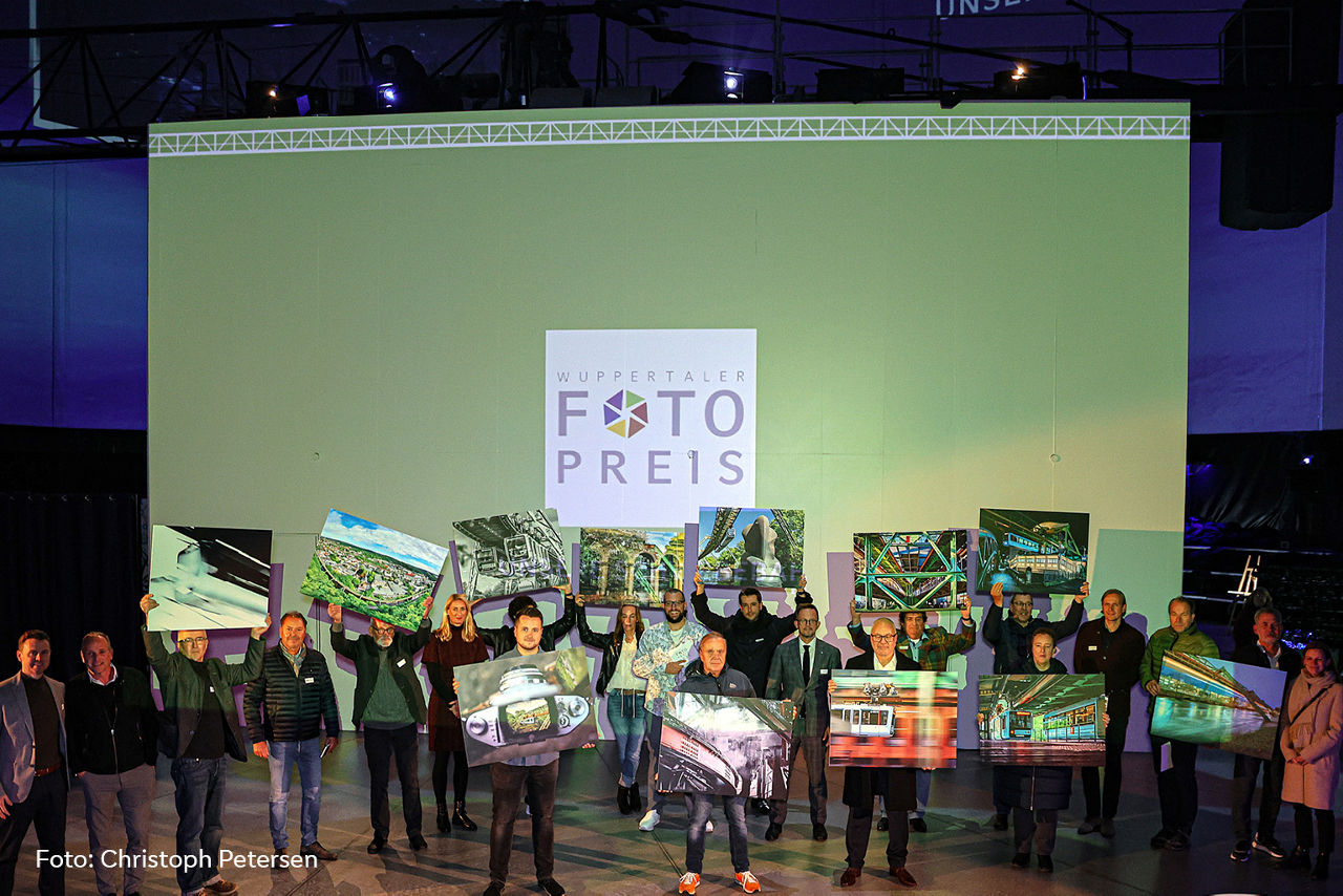 Gewinner und Jurymitglieder halten Gewinnerfotos in den Händen