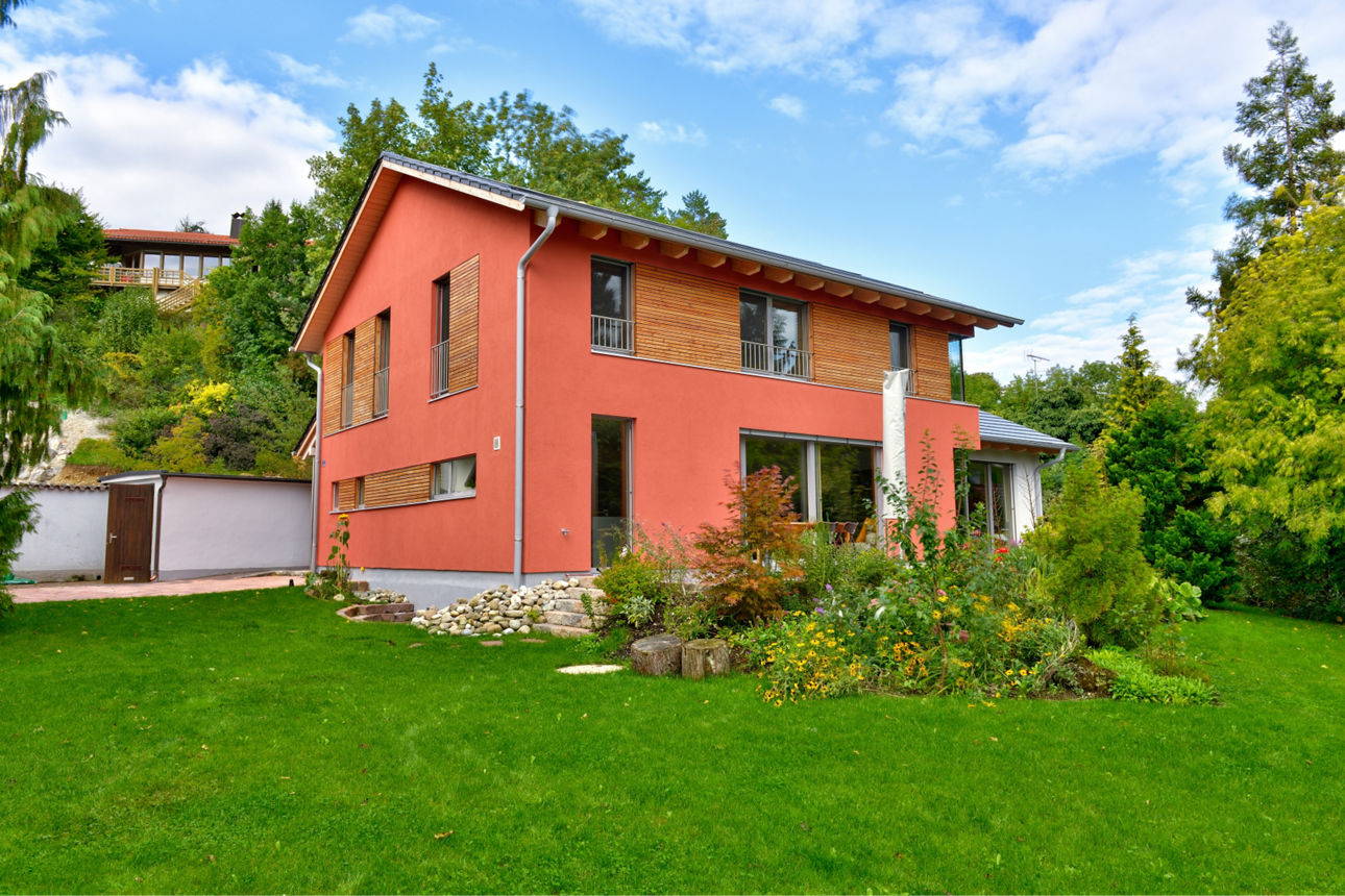 Hellrotes Haus mit grüner Wiese
