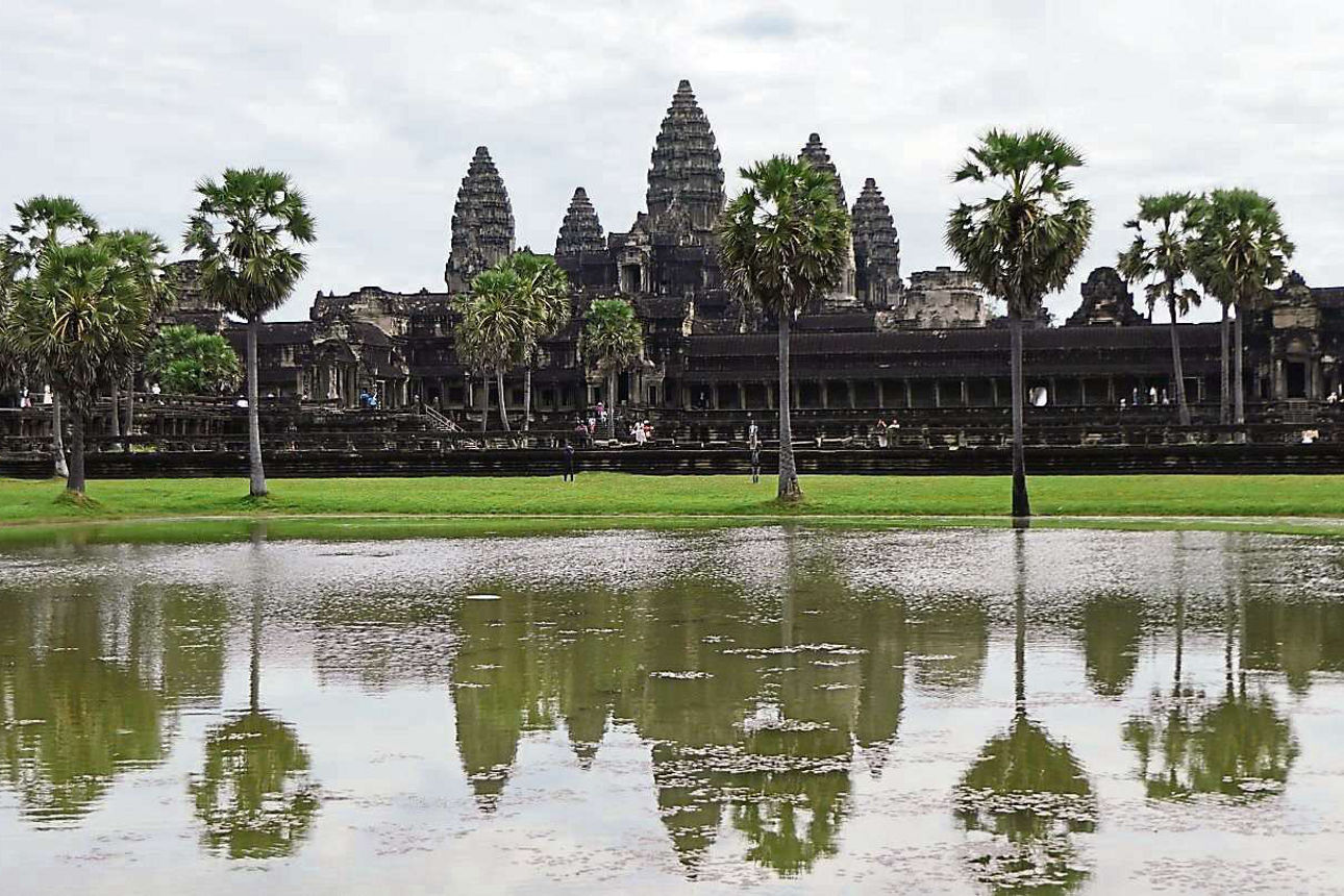 Ein großer Tempel umgeben von einem See und großen Bäumen.