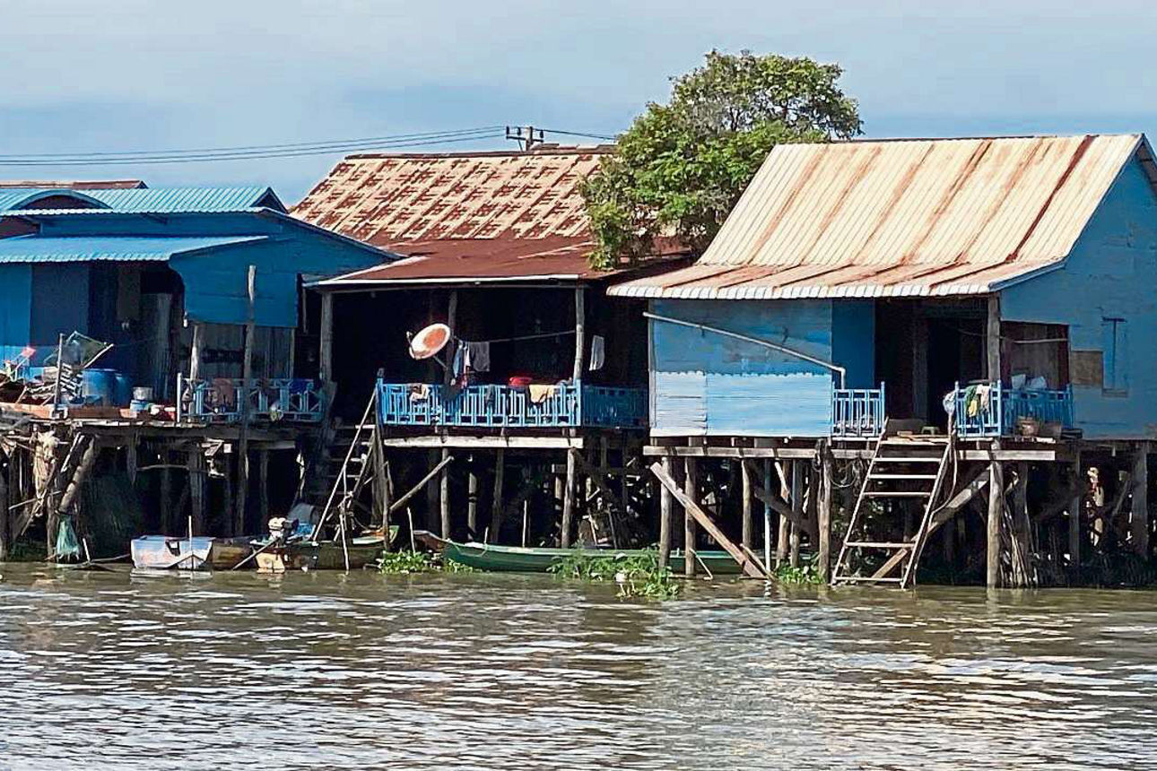 Kleine Häuser die mit Stelzen auf einem See stehen.