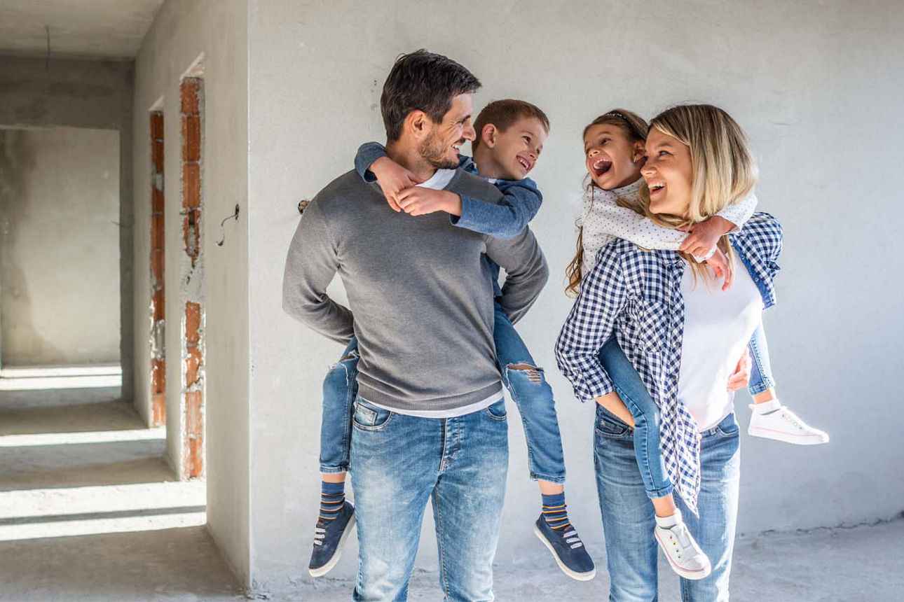 Eine junge Familie spielt im Rohbau ihres Eigenheims