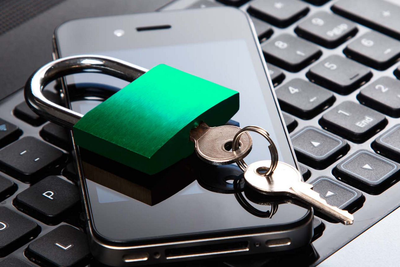 Schwarze Tastatur auf der ein schwarzes Smartphone liegt und ein Vorhängeschloss