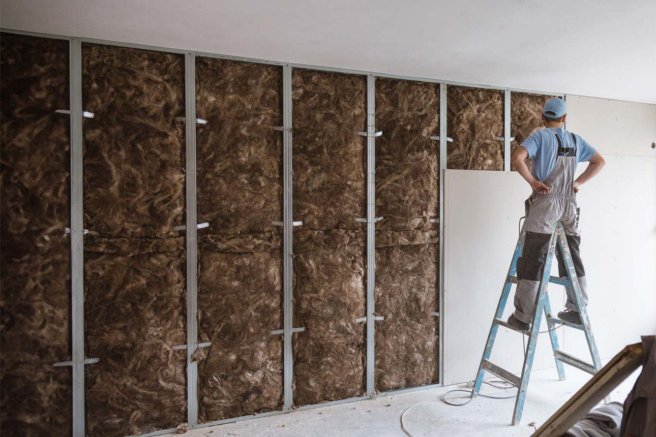 Handwerker baut eine Trockenbauwand inklusive Wärmedammung auf