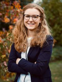 Ein Bild einer Stpendiatin. Sie ist blond und trägt eine weiße Bluse mit blauem Blazer