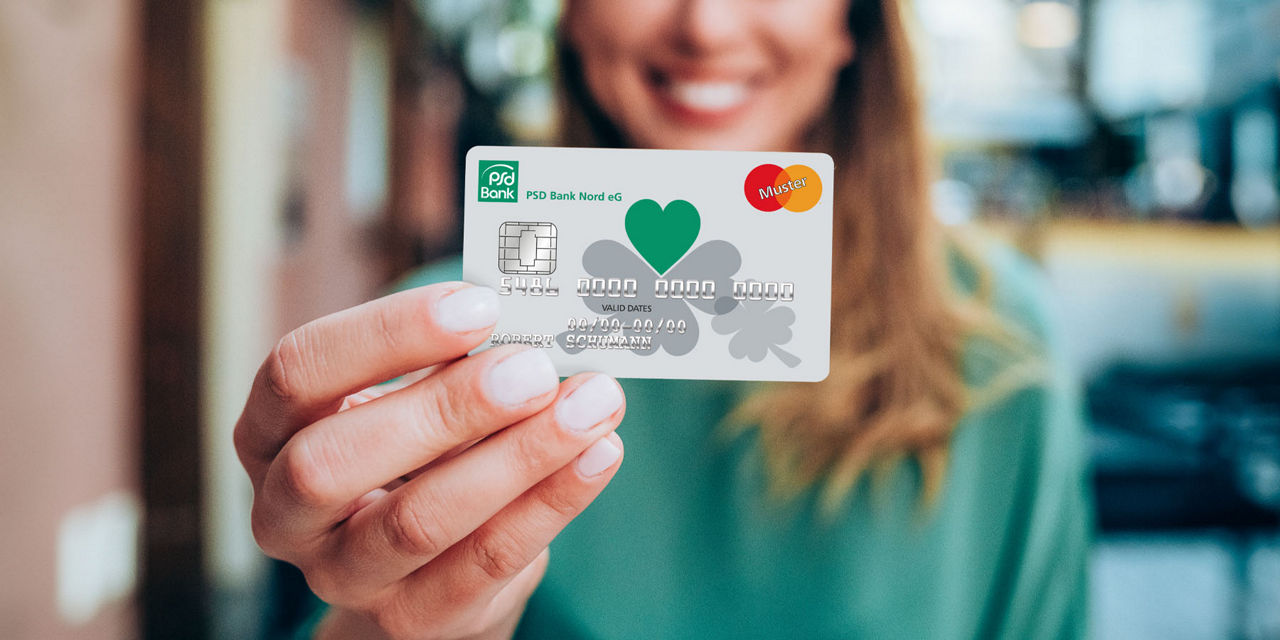 Junge Frau hält Ihre Mastercard der PSD Bank Nord in der Hand