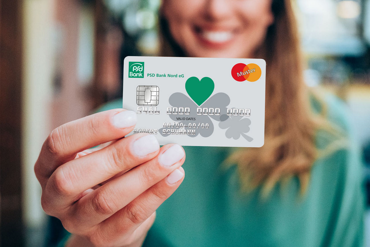 Junge Frau hält Ihre Mastercard der PSD Bank Nord in der Hand