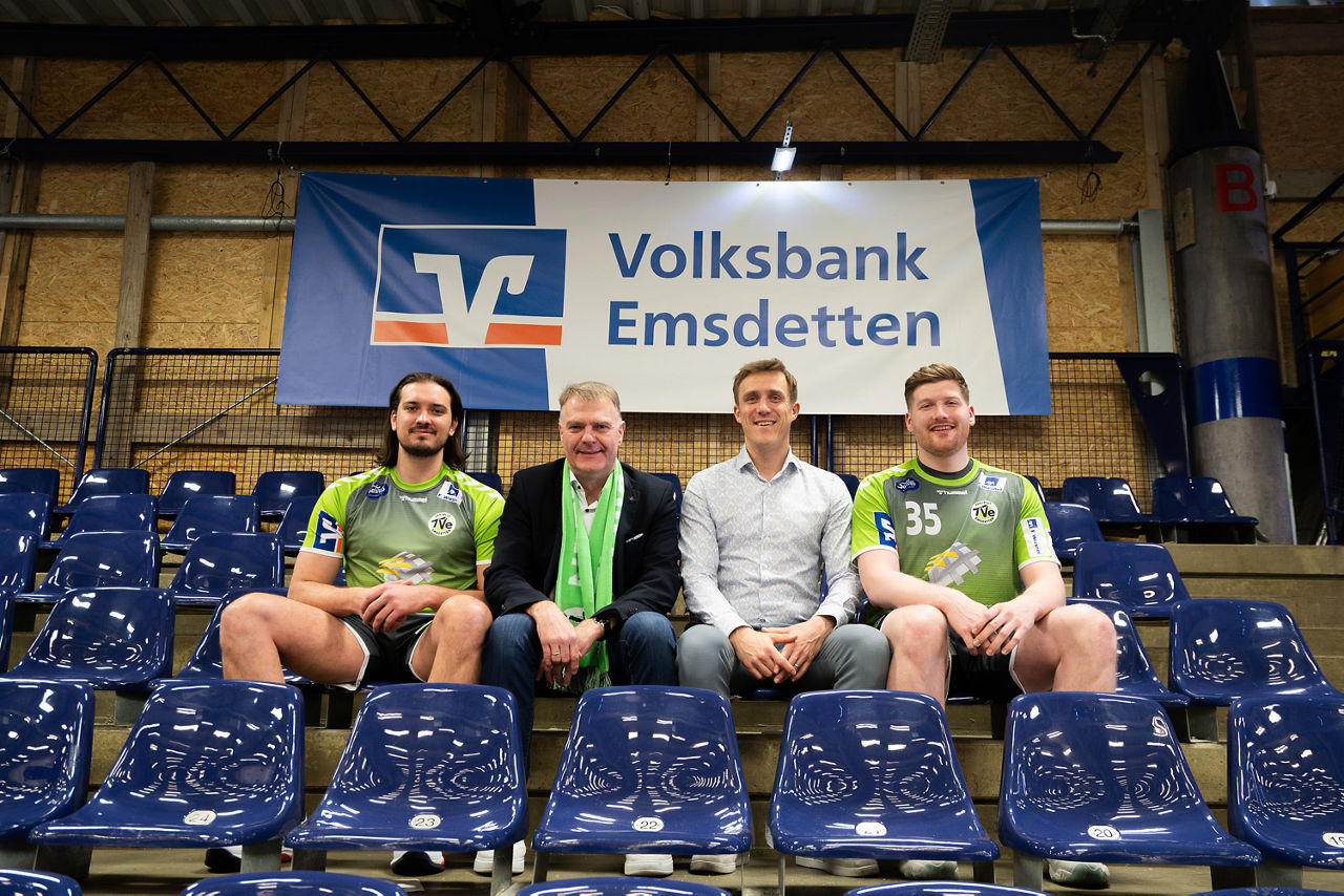Vier Männer sitzen in grünen Trikots auf den Sitzplätzen der Arena vom TV Emsdetten