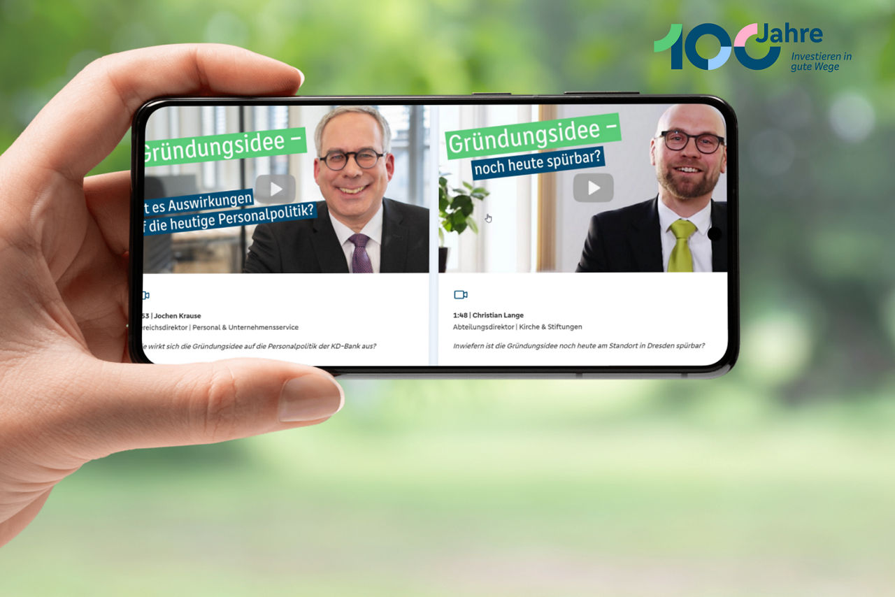 Eine Hand hält ein Smartphone, auf dessen Bildschirm die Teaser der Mitarbeiter-Videos zu sehen sind.