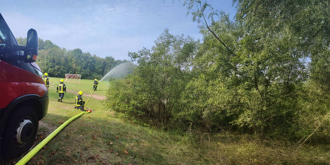 Jugendfeuerwehr übt auf einem Sportplatz