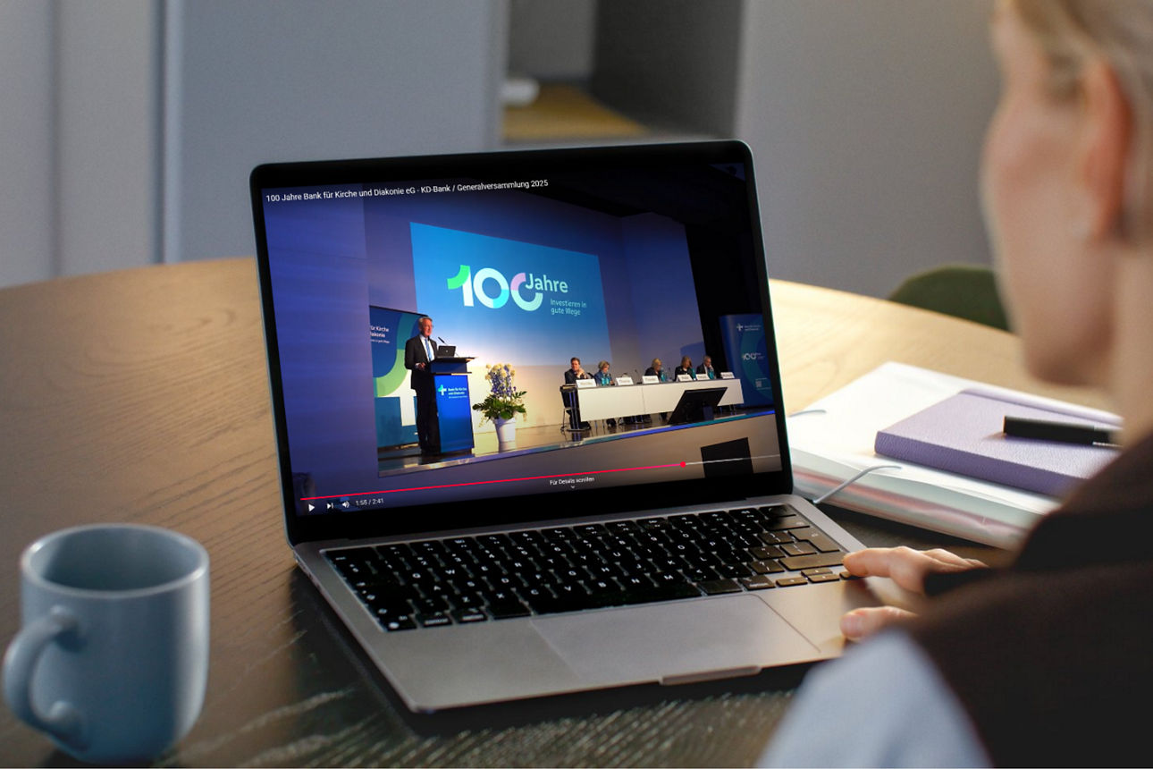 Eine Frau schaut auf einen Laptop, auf dem das Video der Generalversammlung abspielt.