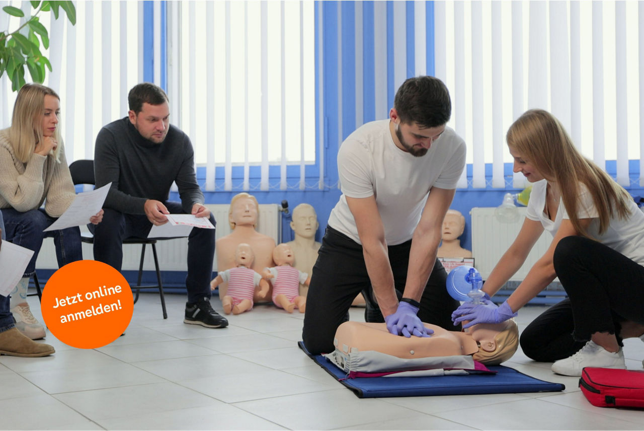 Zwei Personen zeigen Wiederbelebungsmaßnahmen an einer Puppe.
