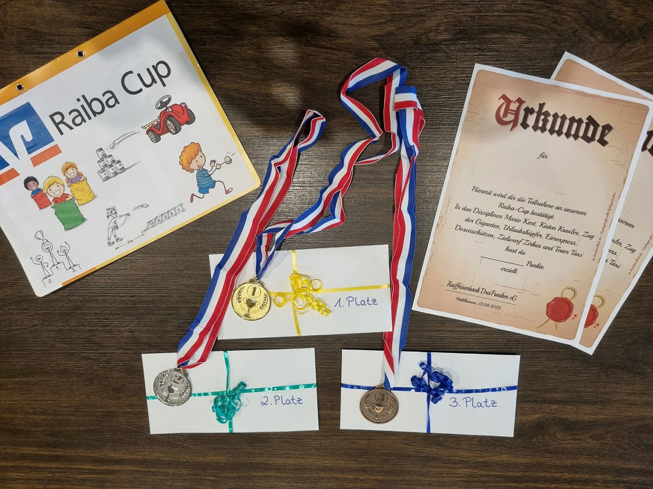Medaillen, Briefumschläge und Teilnehmerurkunden liegen auf einem Tisch