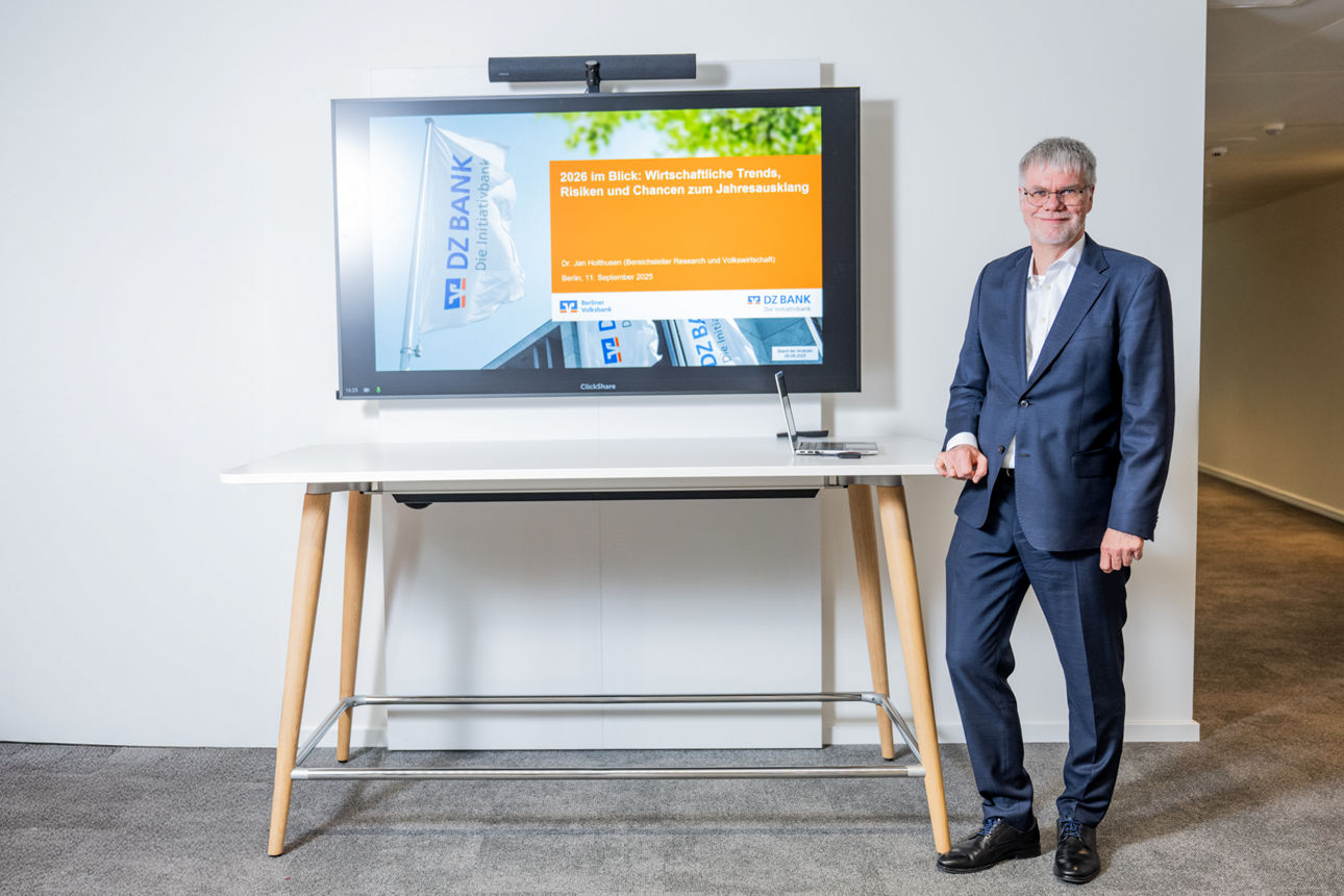 Wirtschaft zwischen Zollchaos und Wachstumshoffnung für 2026 Dr. Holthusen steht an einem Tisch