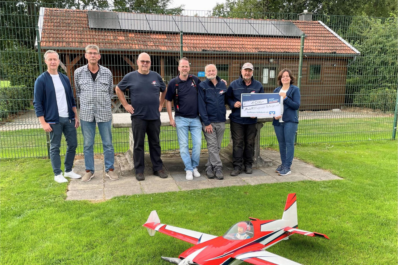 Sieben Personen bei der symbolischen Scheckübergabe