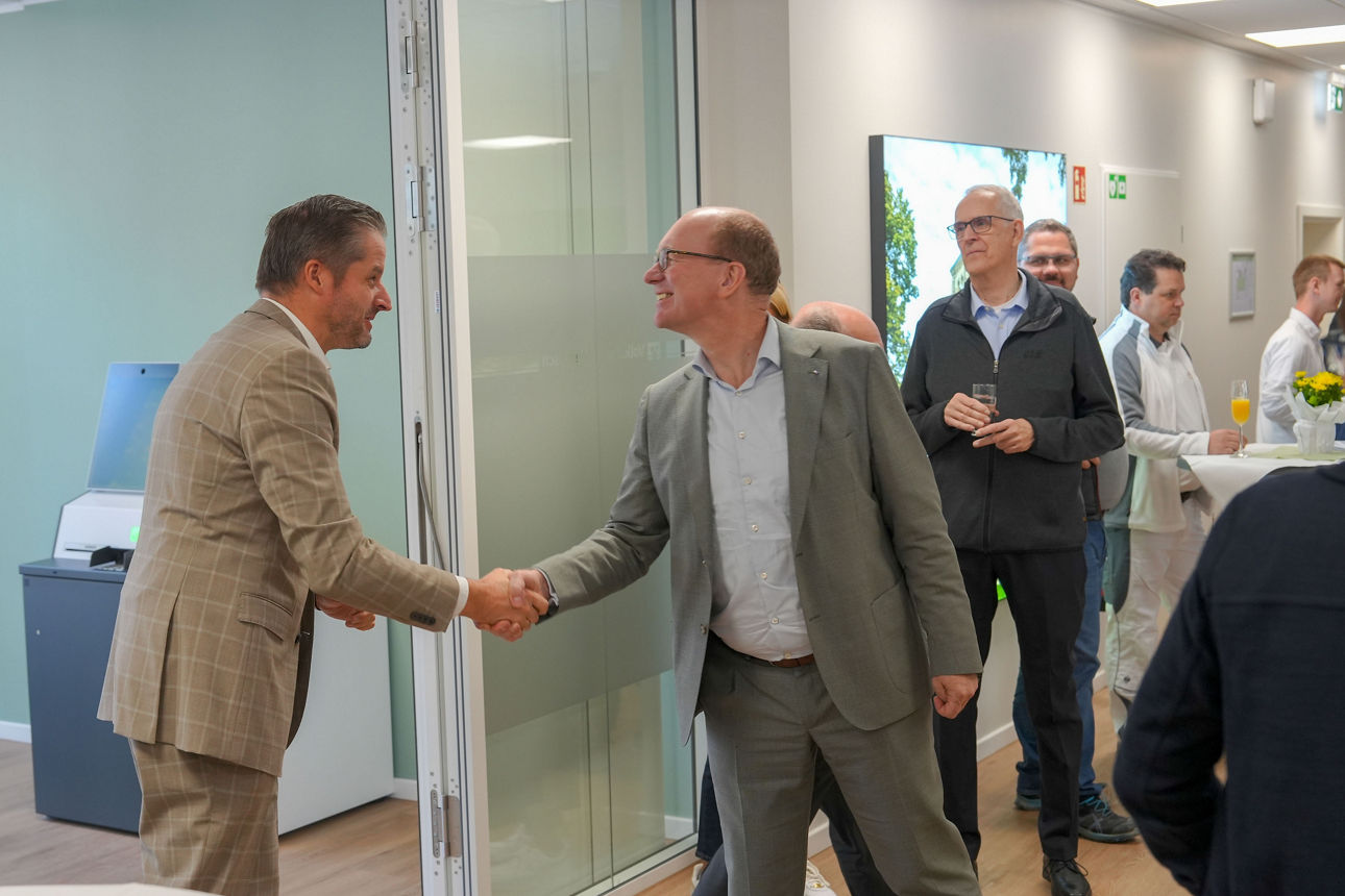 Zwei Männer, der Bürgermeister und Franz Dierk Meurers, schütteln sich die Hand und lächeln in der neuen Filiale.