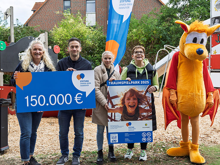 Menschen halten einen symbolischen Scheck und ein Plakat in den Händen