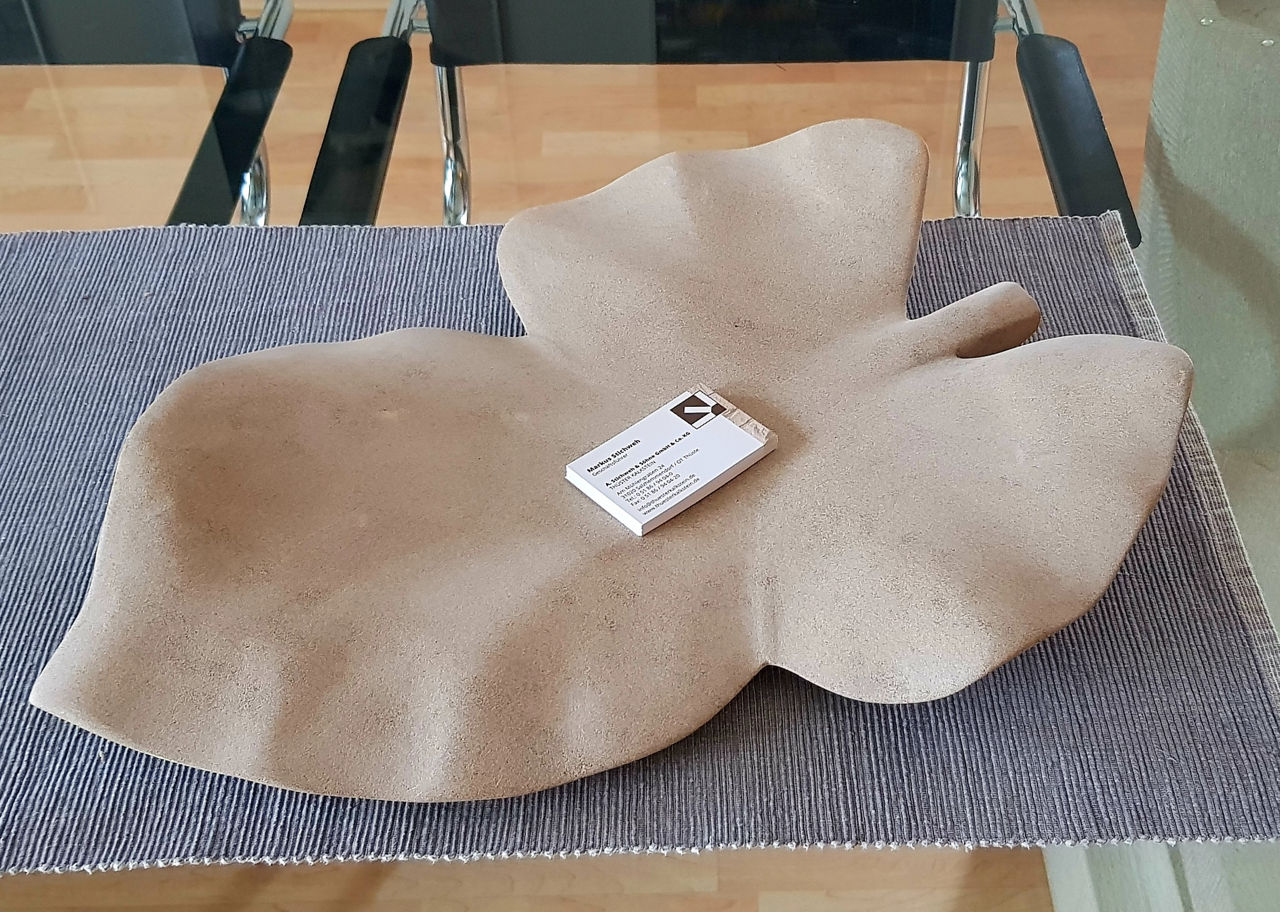 Visitenkarten liegen in einer Schale aus Kalkstein