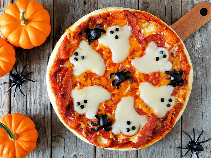 Eine Pizza, belegt mit Käse als Gespenstern und Oliven als Spinnen