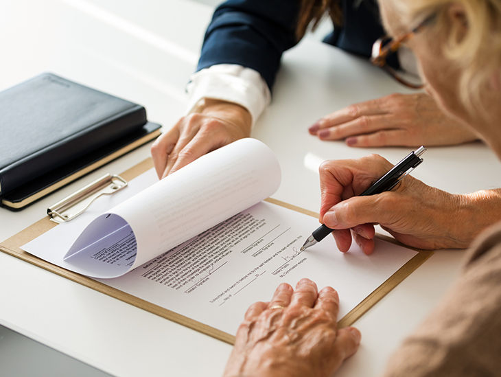 Frau unterschreibt eine Vorsorgevollmacht