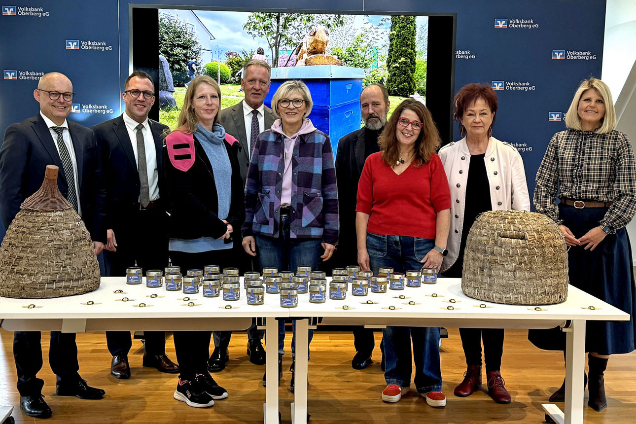 Bei der Spendenübergabe in Wiehl überreichen Vertreter der Volksbank Oberberg Honig aus eigener Herstellung und 15.000 € an Vertreterinnen und Vertreter der oberbergischen Tafeln.