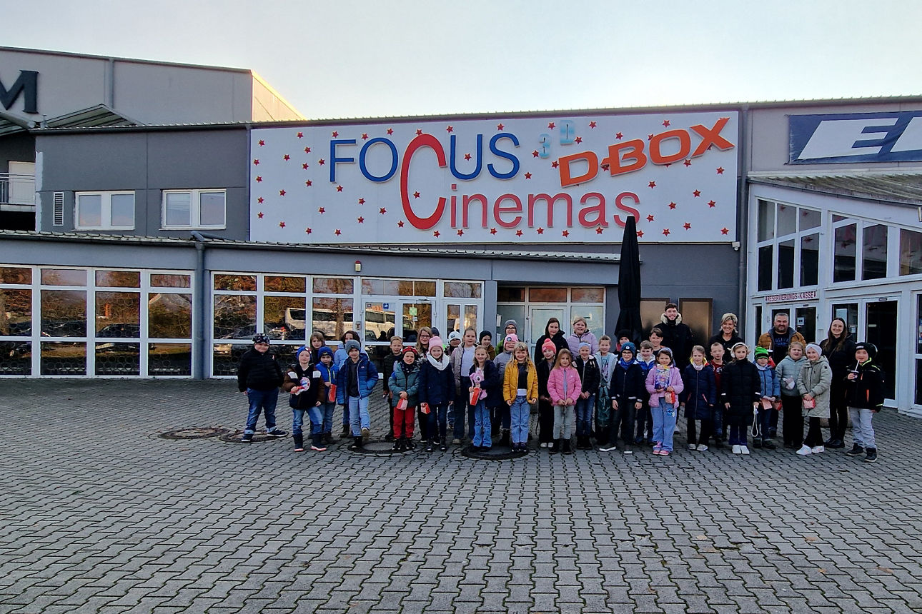Gruppe aus Kindern mit den Betreuern vor dem Kino