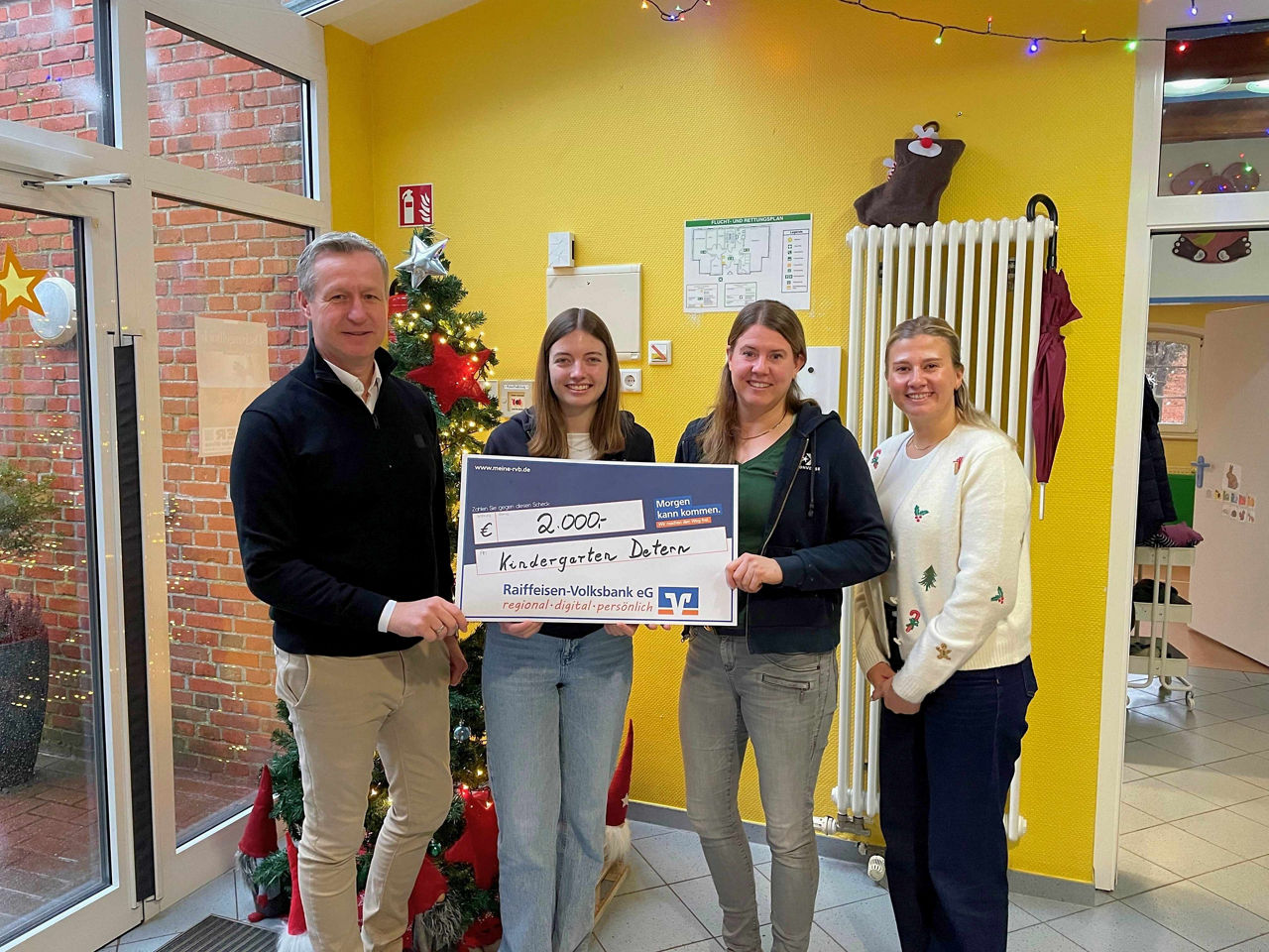 Vier Personen mit Spendenscheck