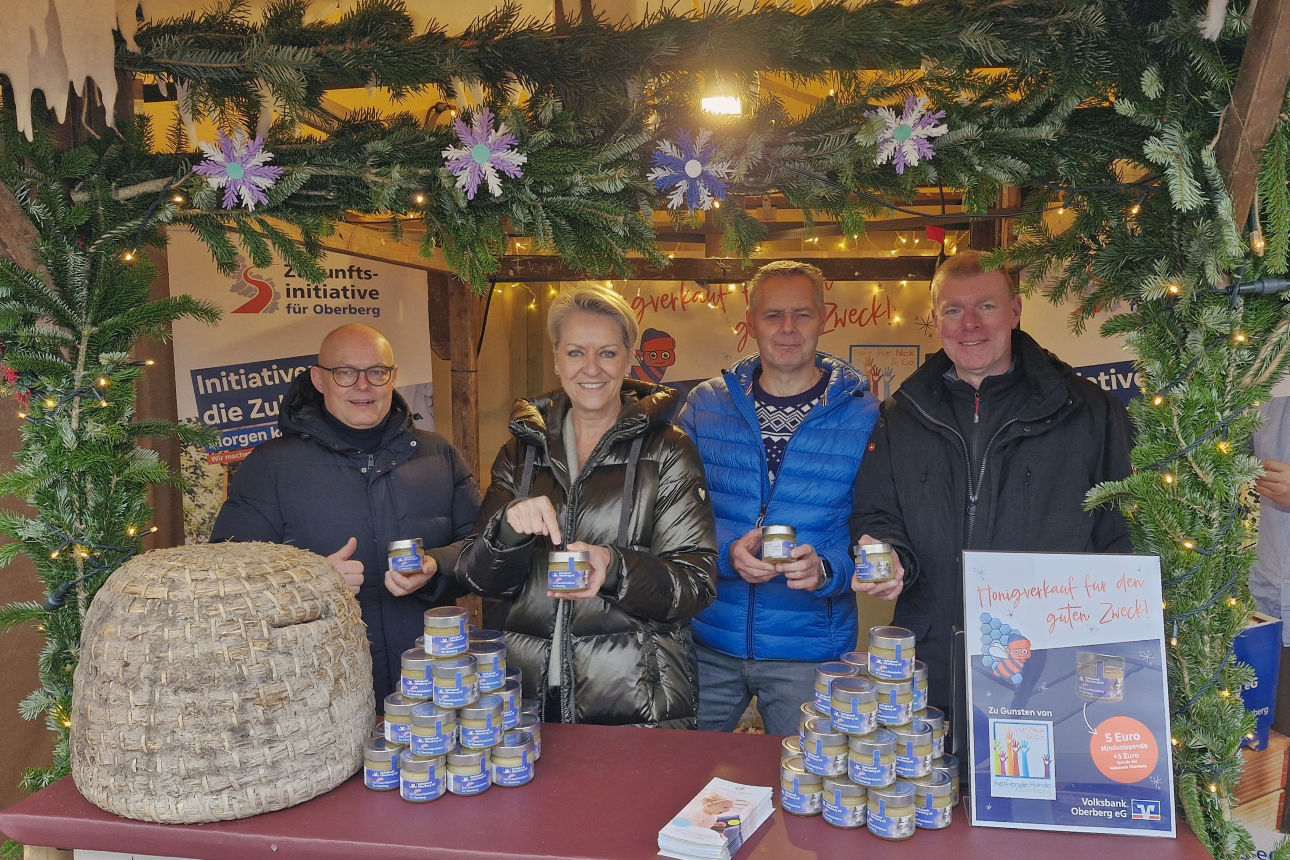 Vier Personen stehen im Winterdorf Gummersbach, lächeln in die Kamera und halten Honiggläser hoch. Zu sehen sind Jörn Richling, Bettina Hühn, Henning Zöller und Stefan Leitzke.