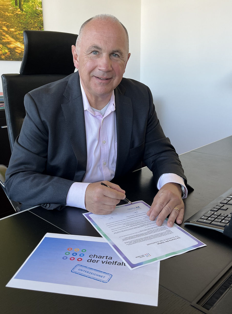 Manfred Klaar, Raiffeisenbank im Oberland, unterzeichnet die Charta der Vielfalt.