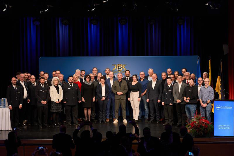 Eine Personengruppe steht auf einer Bühne und erhält eine Auszeichnung