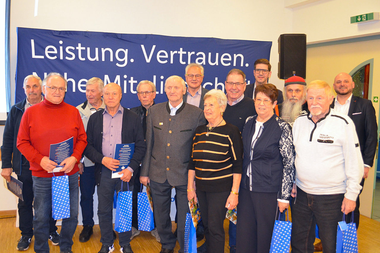 Kunden stehen mit großem Spendenscheck nebeneinander